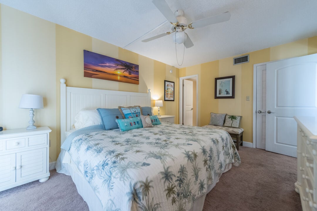 Elegant master bedroom with tropical-themed decor and plush bedding.