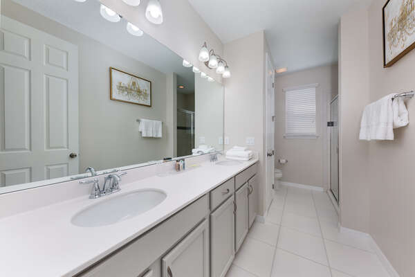 En suite bath with double vanity sins and sizable shower