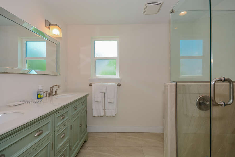 Large guest bathroom of this home for rent new Smyrna beach with walk-in shower and 2 sinks.