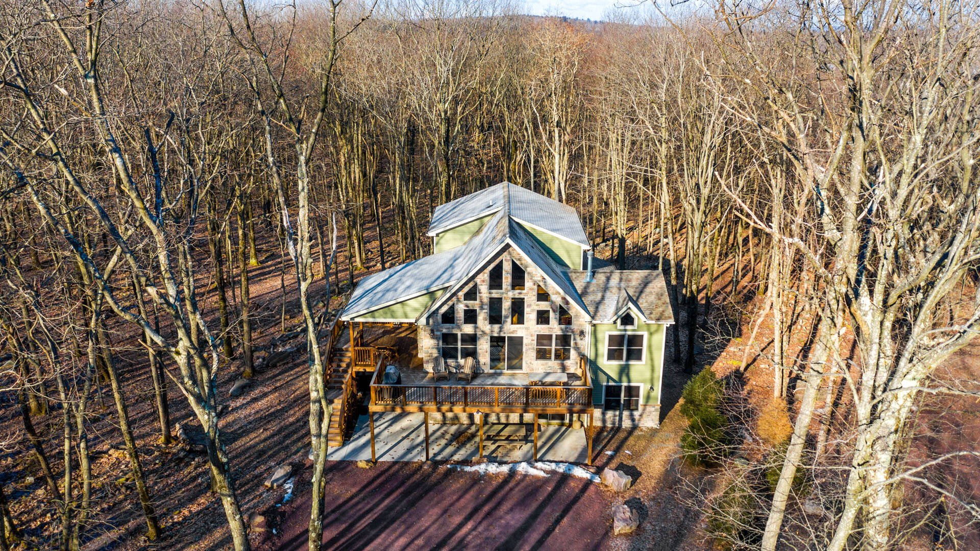 Aerial shot of this luxurious Poconos vacation rental, showing the surrounding forest.