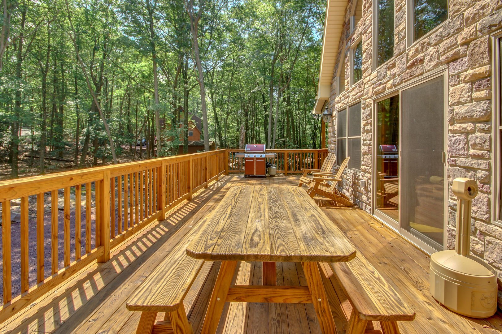 Picnic table and grill on the porch of this luxurious Poconos vacation rental.