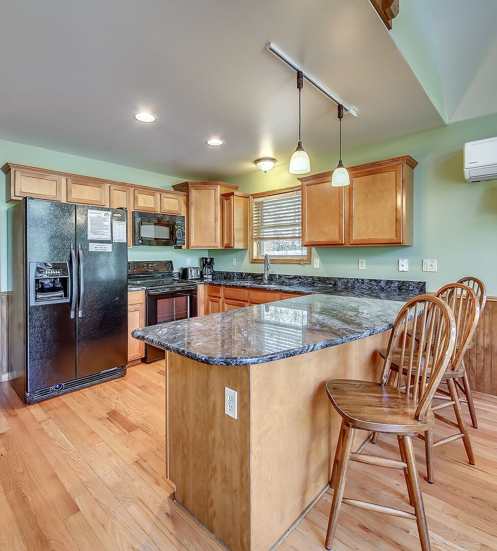 Alternate Angle of the Kitchen - with Island, Fridge, and Bar Seating - in our Vacation Rental