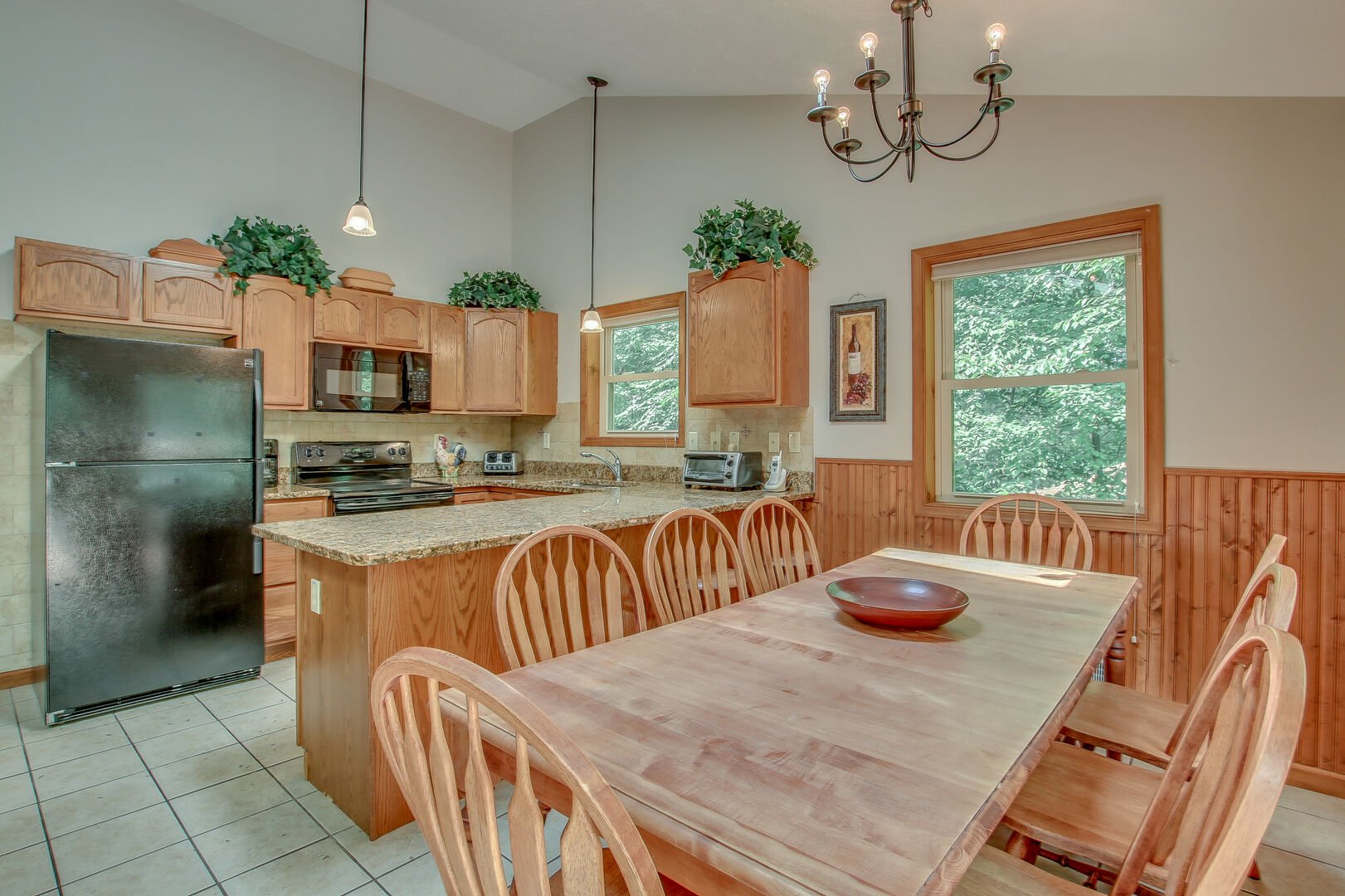 Picture of the table and chairs, refrigerator, microwave, and oven in the kitchen of this Lake Harmony rental.