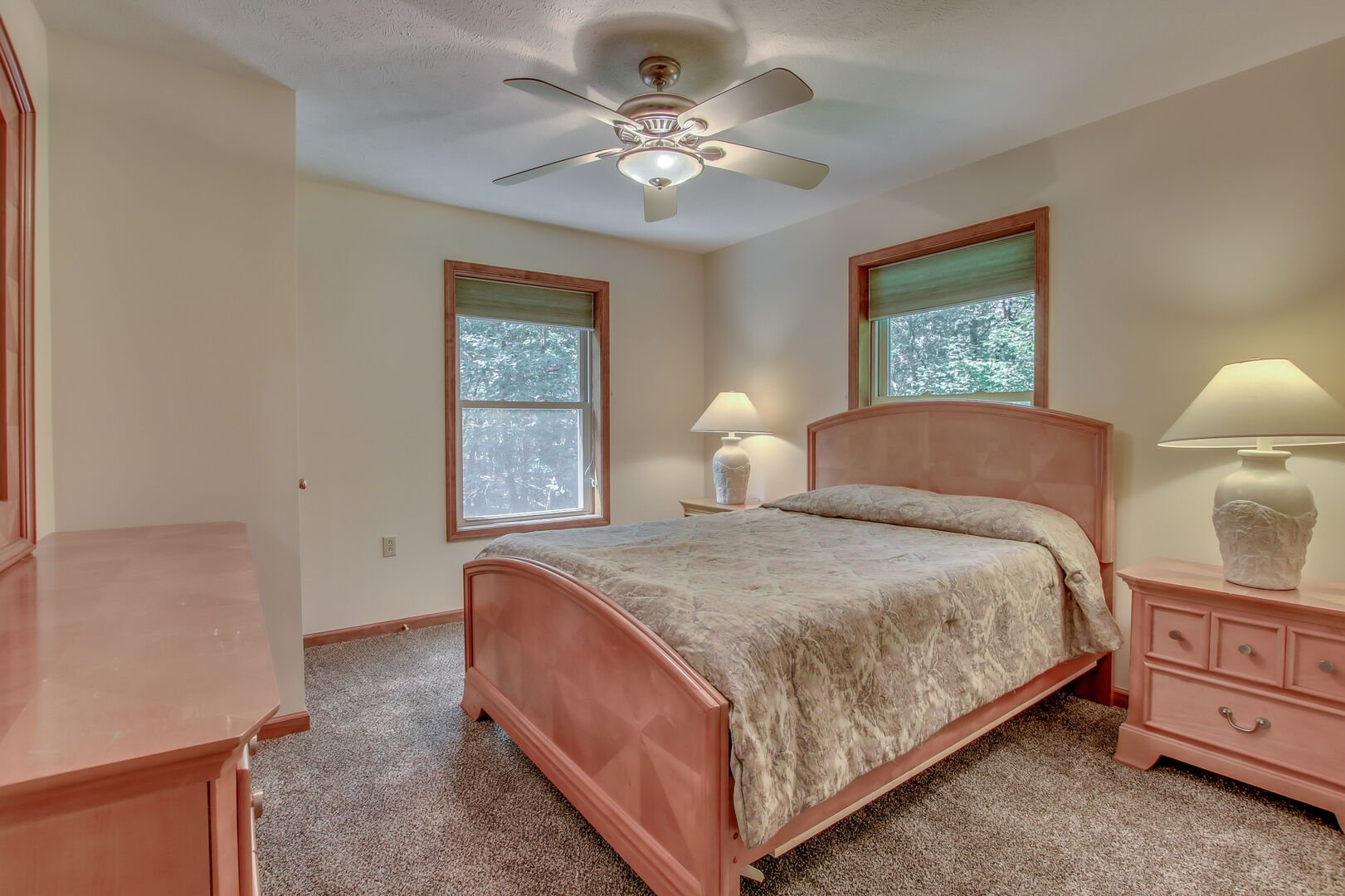The bed in the master bedroom, with two nightstands on either side, and a vanity dresser at the foot of the bed.