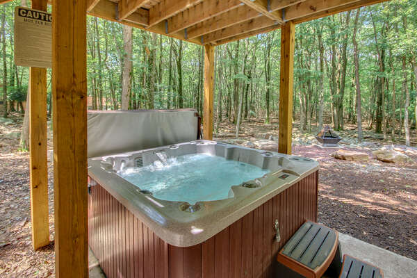 The outdoor hot tub of this luxurious Poconos vacation rental, filled with water and powered on.