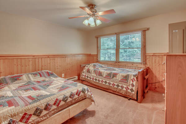 One of the bedrooms in this Pocono rental in Towanensing Trails, with a bed and couch against the wall.