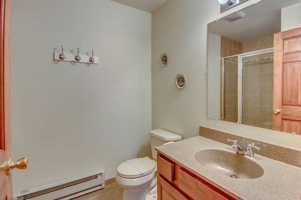 Sink, Mirror, and Toilet of the Bathroom with Shower.