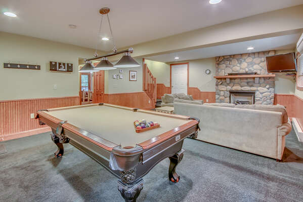Downstairs Game Room, with Pool Table, Couches, and a Fireplace.