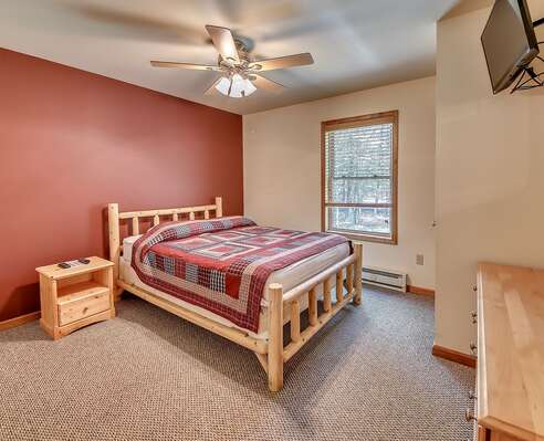Bedroom with One Bed, Night Stand, and Flat Screen TV in our Poconos Lodge Rental