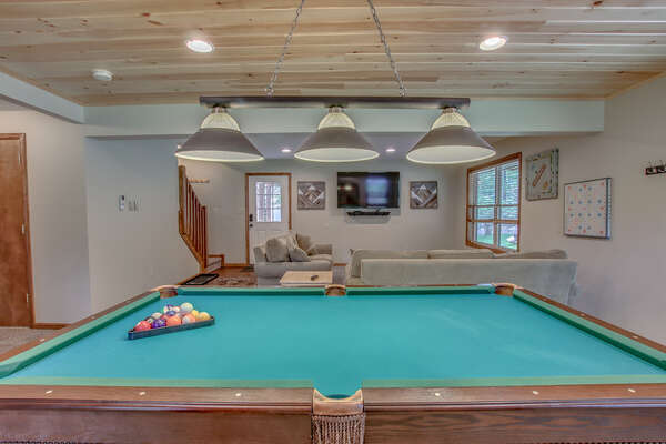 basement with pool table and couches