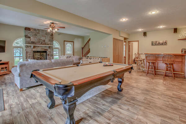 Game Room with Pool Table, Bar Counter, High Chairs, Couch, and Fireplace.