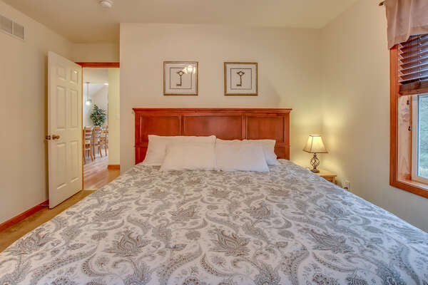 Front Picture of a Large Bed with Nightstand and Lamp.