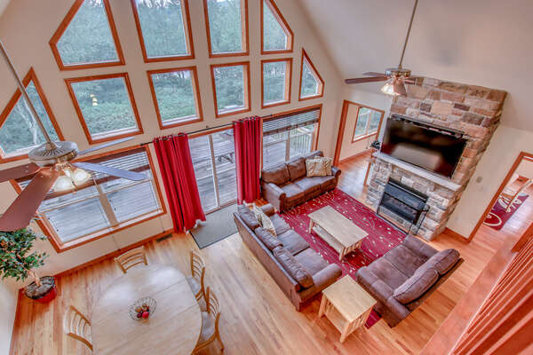 Great Room with Floor to Ceiling Windows, Fireplace, TV, Couches, and Dining Area.