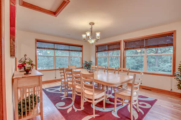 Dining Table with Eight Chairs, Ceiling Lamp, and Windows.