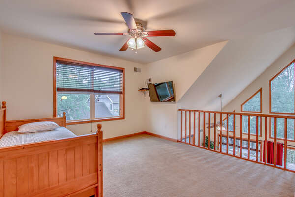 Upstairs Room with One Bed, Ceiling Fan, and TV.