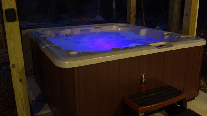 Outdoor hot tub lit up at night