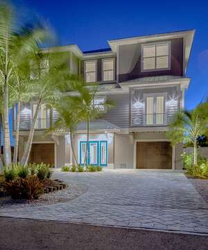 Front exterior of this vacation house for rent in Fort Myers FL, highlighted by palm trees.