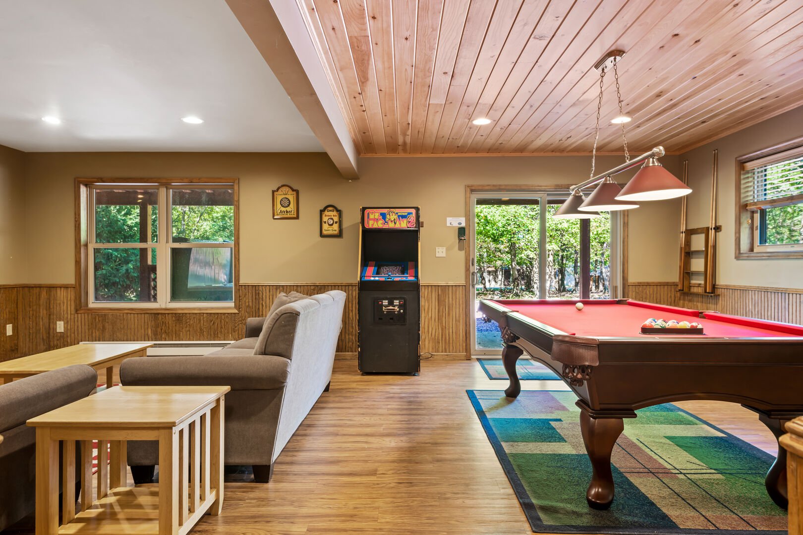 basement with couches, arcade machine and pool table