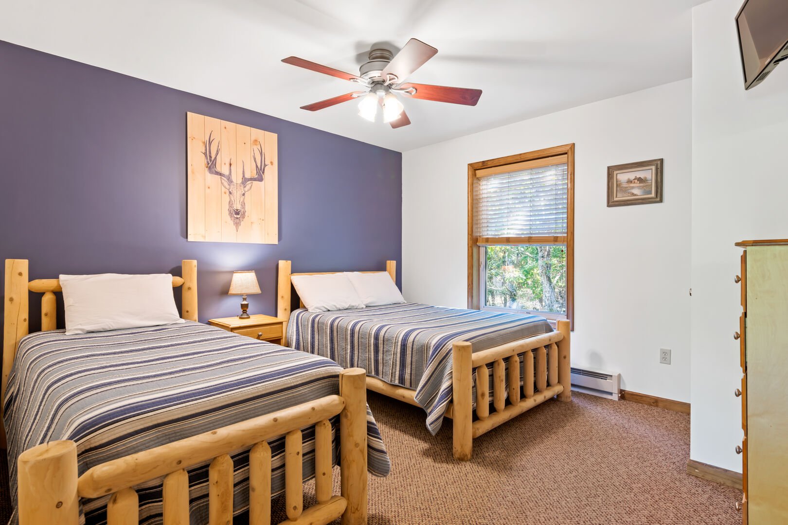 blue bedroom with two beds and a ceiling fan