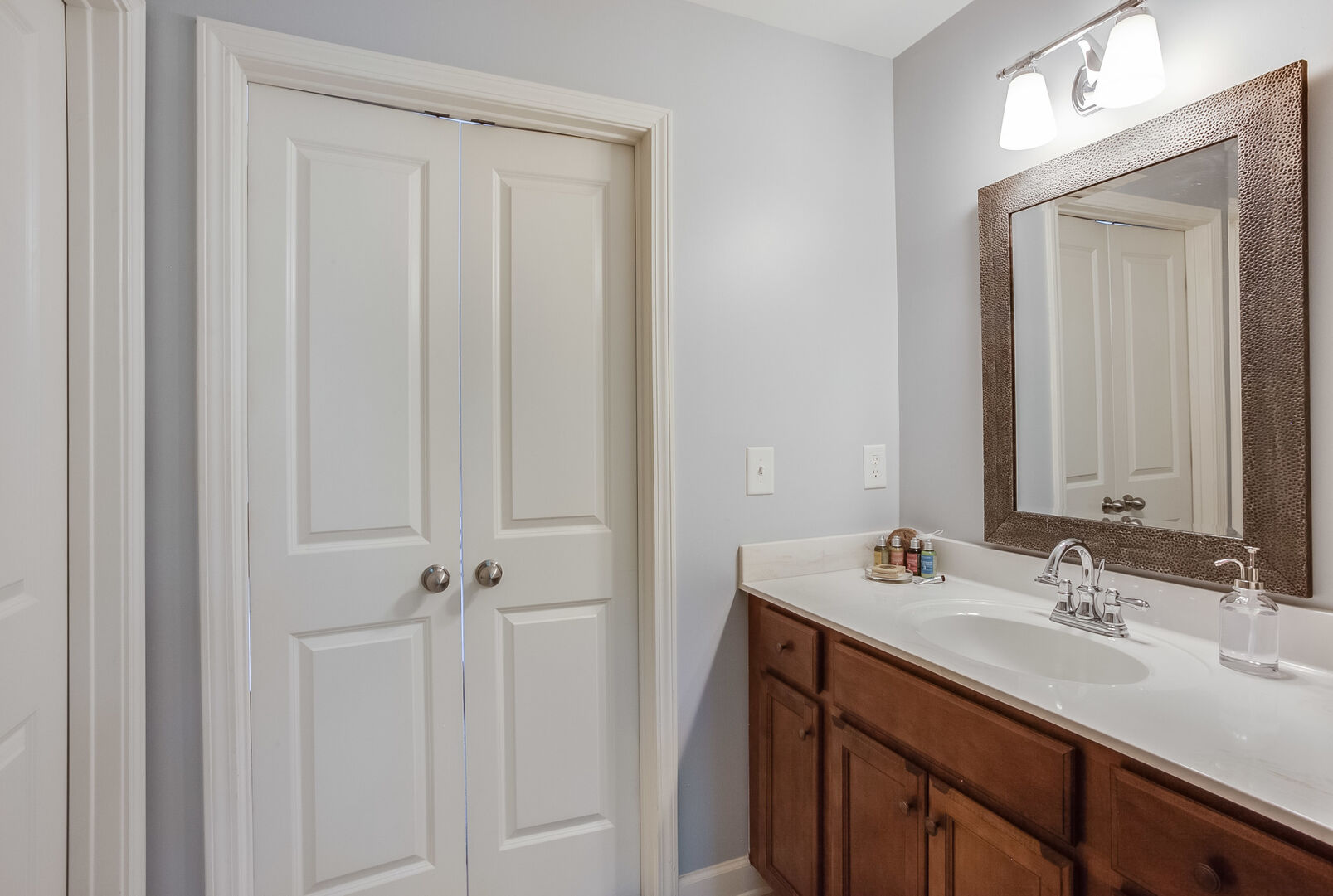 Single Vanity Sink, Mirror, Lamp, and Door.