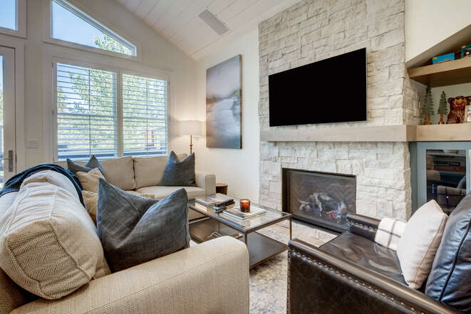 Living Room with All New Furnishings, a Gas Fireplace, Stone Wall with a Smart TV and Plenty of Natural Light