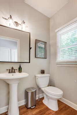 Bathroom with Pedestal Sink, Toilet, and Mirror.