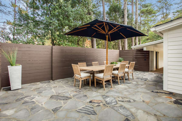 Outdoor Dining Table with Umbrella, Chairs, and in the Backyard.
