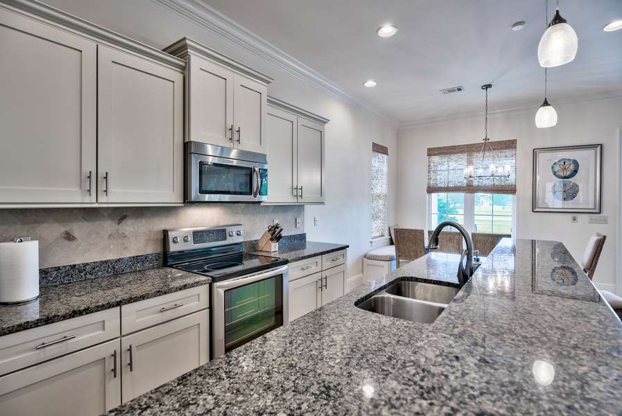 Open concept kitchen stocked with lots of cookware, coffee makers, grinder, wine chiller fridge, blender, etc.