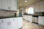 Kitchen with granite countertops, custom panel cabinetry with stainless steel appliances.