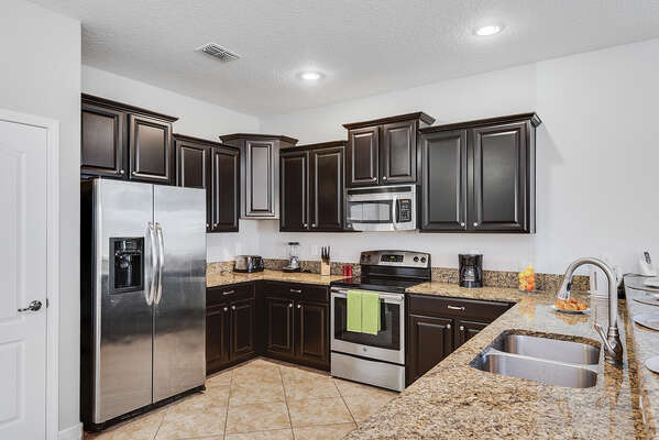 Custom kitchen cabinetry, marble countertops and stainless steel appliances