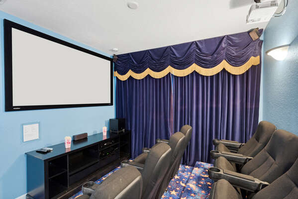 The theater room has a large projection screen, surround sound and stadium style seating