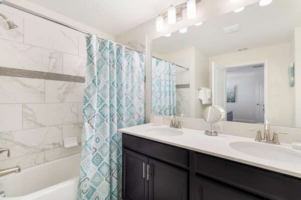 The en-suite bathroom has dual vanity and shower/tub combo