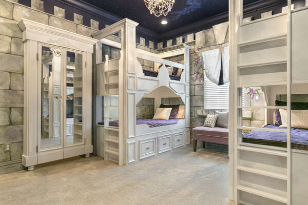 The princess castle themed kids bedroom has custom built twin over twin bunk beds