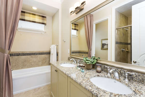 Ensuite bathroom with dual sink, walkin shower, and tub