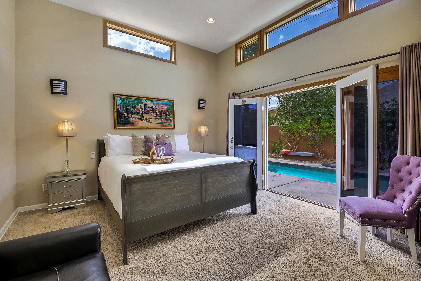 The Master Bedroom Suite features a King-size bed, Queen sofa sleeper,  Smart TV, and private double french doors that lead to the pool and spa.