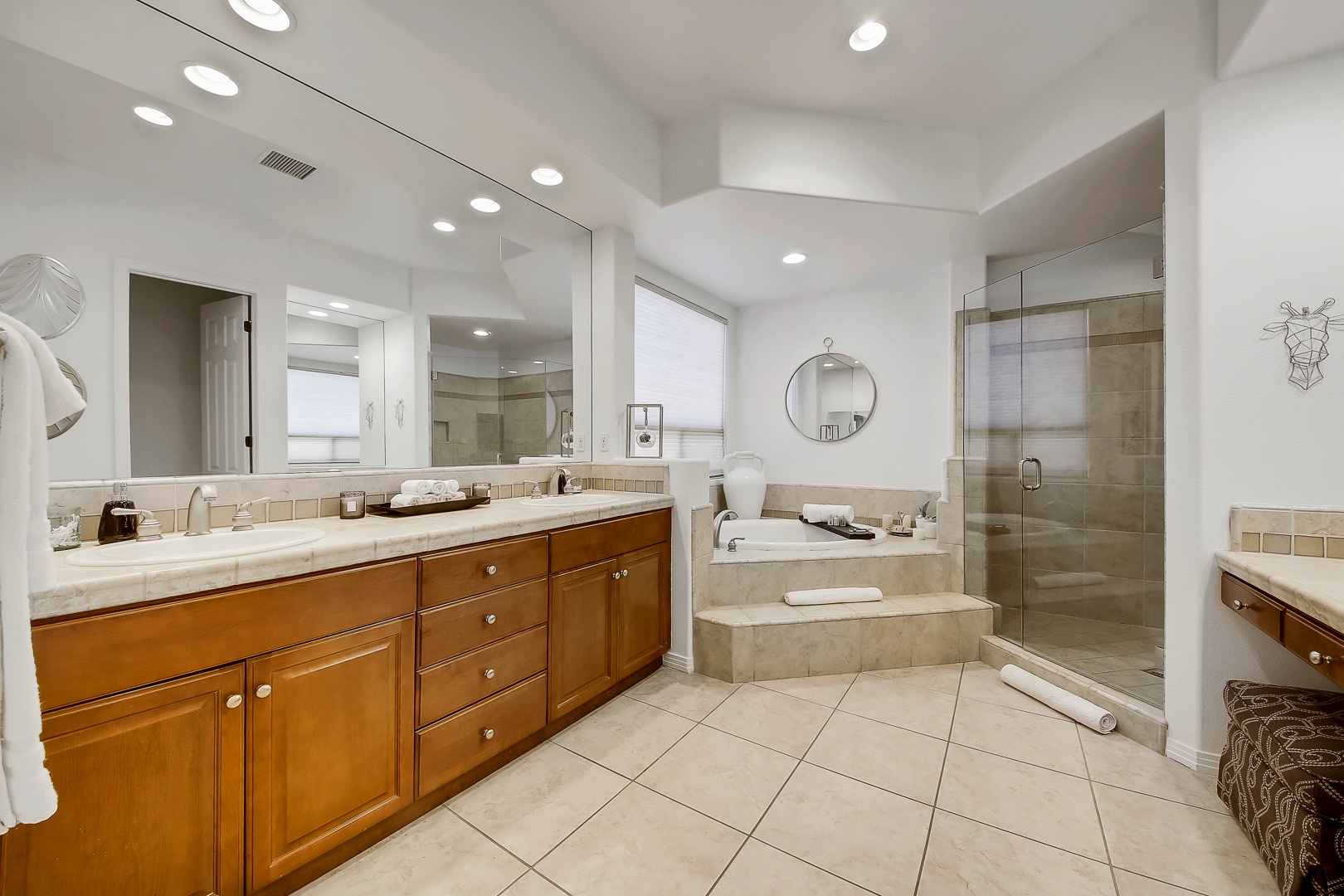 The private, en suite bathroom features a soaking tub, tile shower and double vanity sinks with a makeup counter.