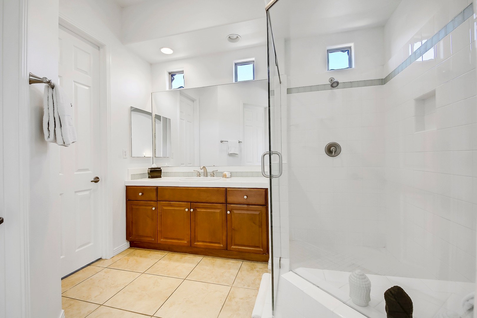 The private, en suite bathroom features a tile shower and a vanity sink.