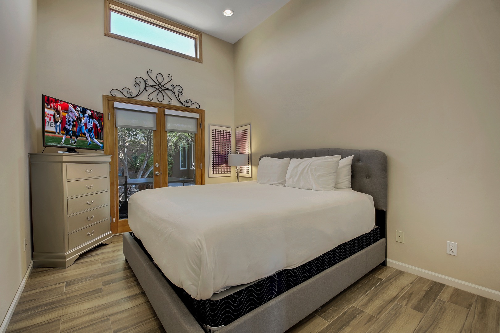 Bedroom 5 has a King-sized bed, Smart TV, reach-in closet and exterior doors to the ping pong patio.