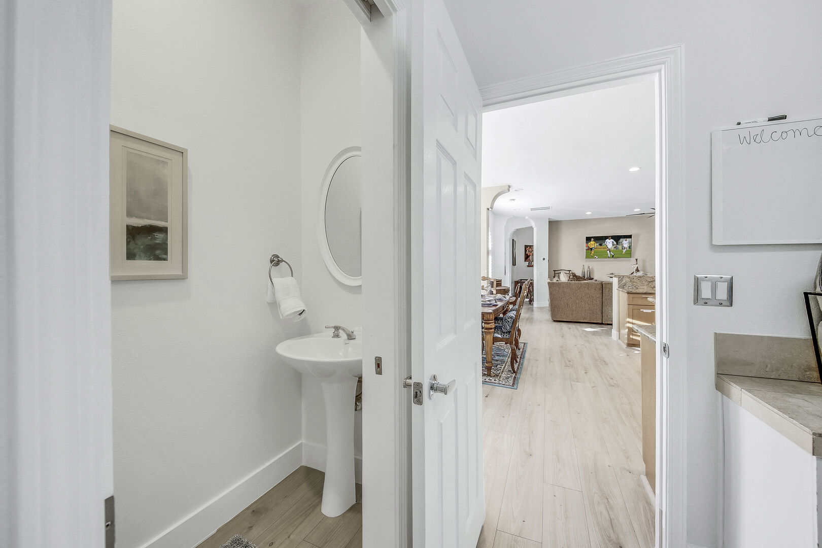 The hallway powder room is located inside the Laundry room and features a pedestal sink.