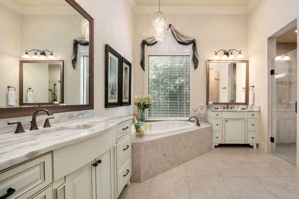 The master en-suite bathroom features his and hers vanity, garden tub, and walk-in shower