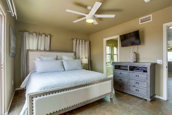 Master Bedroom with Cal King Bed, wall mounted TV and dresser.