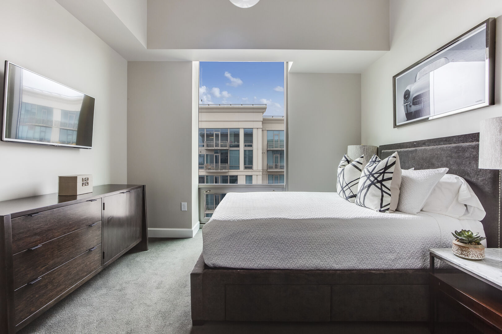 This Atlanta Vacation Rental has a bedroom with wall mounted TV and large window