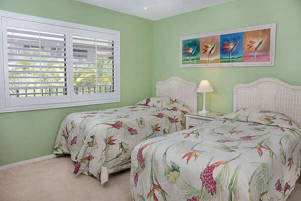 Guest bedroom offers twin beds and natural light.