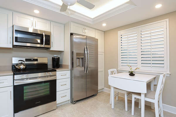Kitchen with stainless steel appliances and small breakfast table
