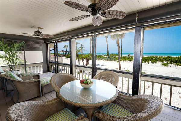 Screened-in lanai with outdoor dining table and seating