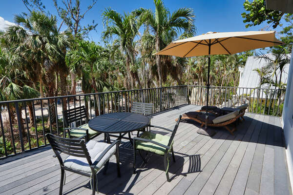 Outdoor area with dining table and sun loungers
