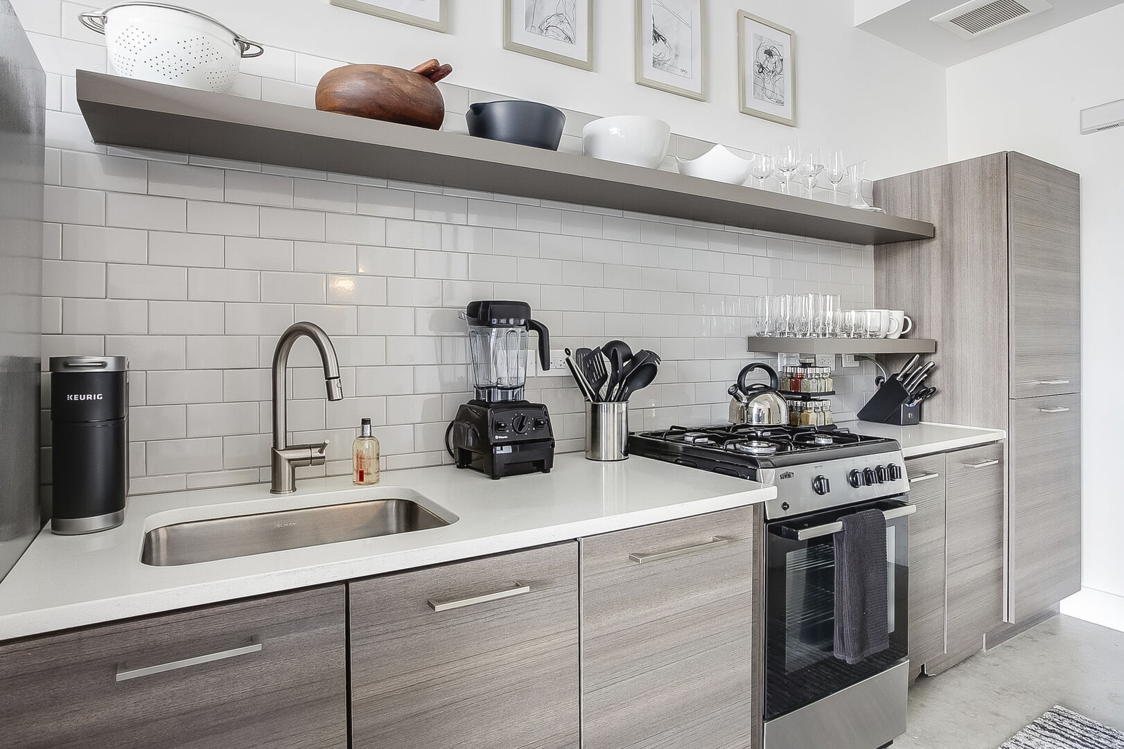 The kitchen of this Ponce City Market rental with modern appliances and a deep sink.