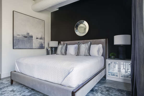 The sleeping area of this Ponce City Market rental with large bed and nightstands.