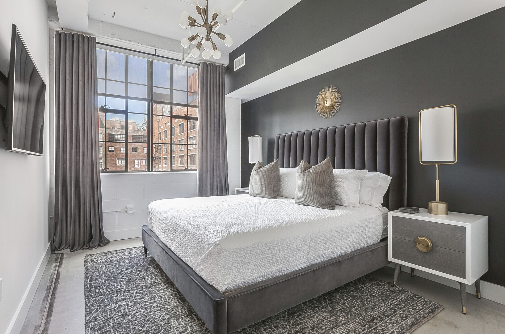 Bedroom of this Ponce Market Apartment with a large bed and twin nightstands.