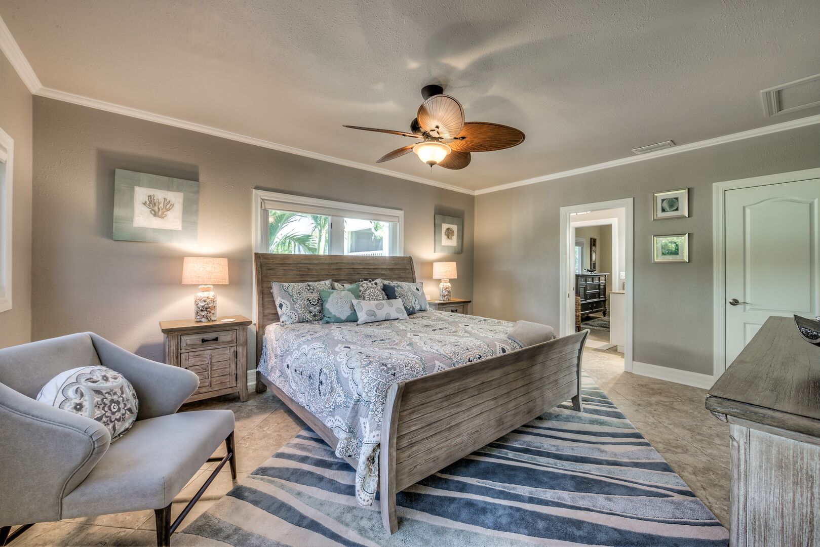 Master bedroom with king bed and chair in our Fort Myers cottage